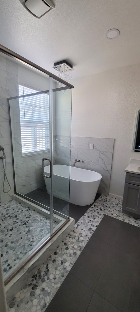 Modern bathroom with white soaking tub and black walk-in shower, Roseville CA tile contractor